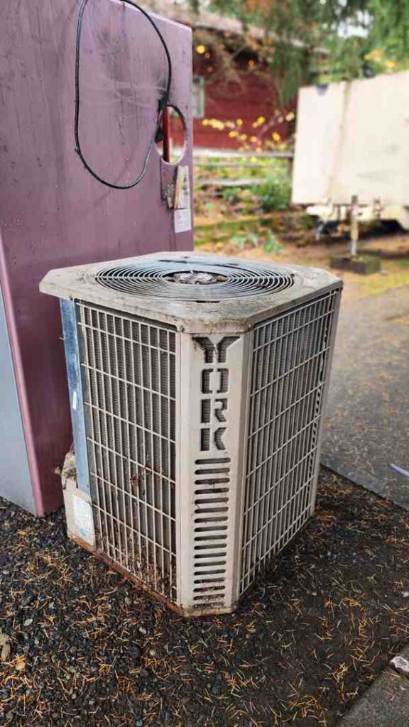 aging outdoor air conditioning unit with visible wear and weathering outside a home - how old is too old for an hvac system